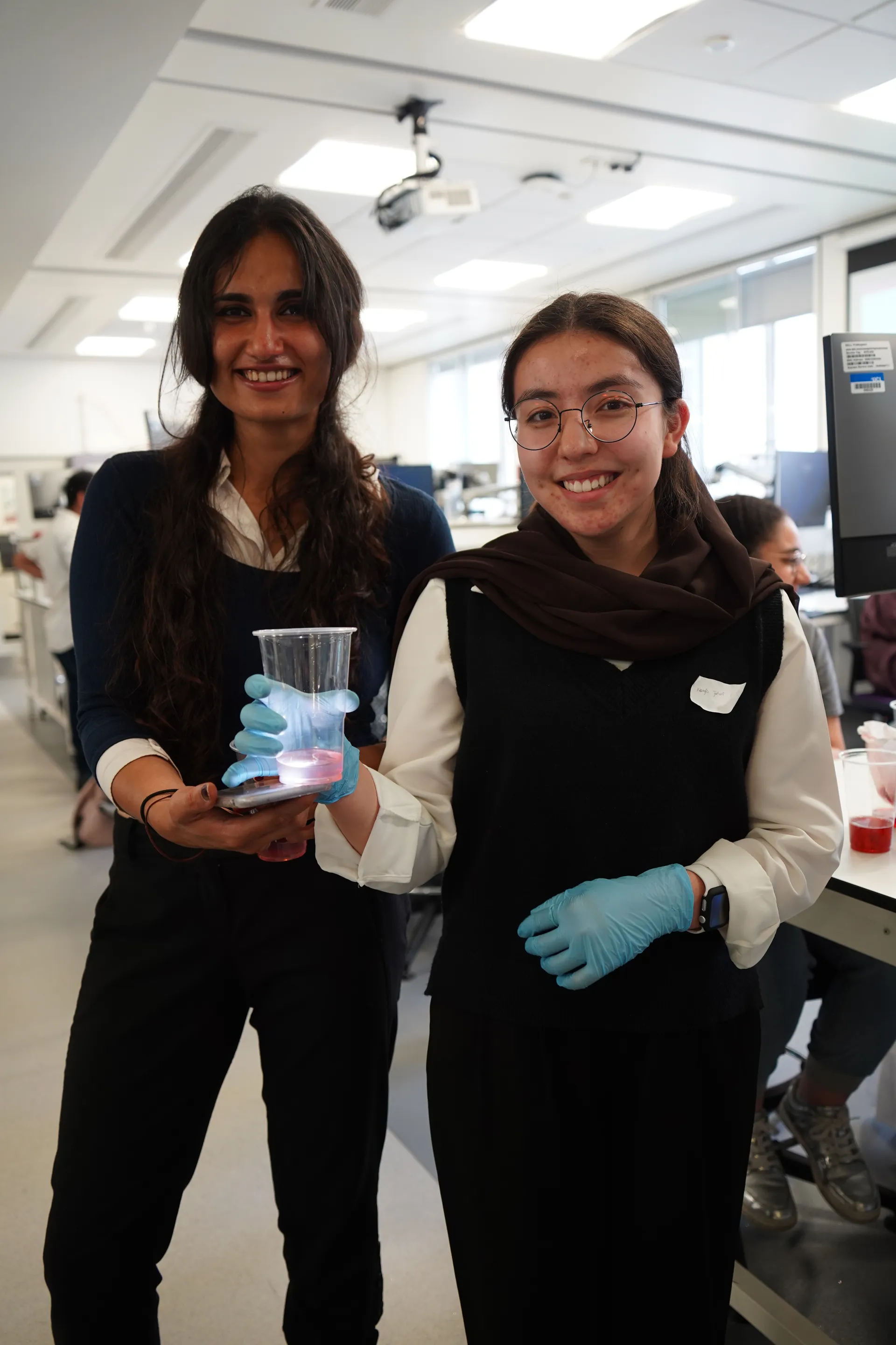 Two students showing the DNA they extracted in a biology workshop